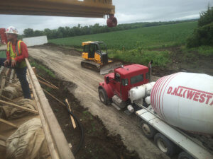 A cement truck drives into the bridge construction area.