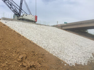 Gravel is laid on the incline beneath the bridge.
